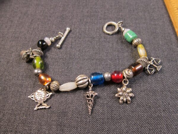 Pretty beaded toggle bracelet w/sterling silver charms fish flower pot etc